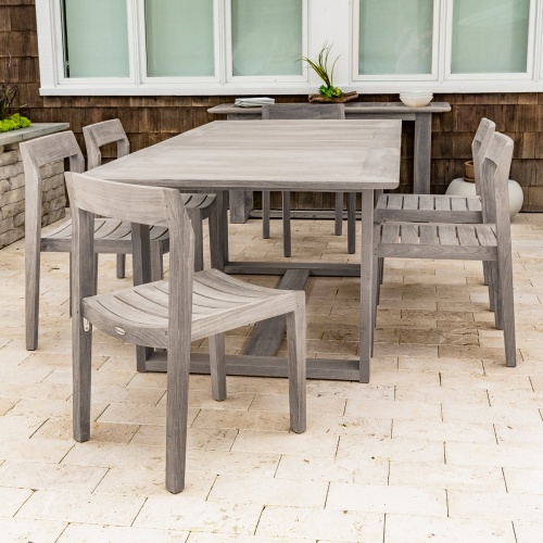 70498 Horizon 7 piece Side Chair Dining Set in silvered finish on concrete patio with wood shingle house with large windows